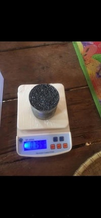 a bowl of black sand on a scale